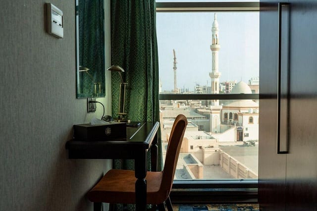 میز کار اتاق هتل آوینا قشم با پنجرهٔ رو به بنای گنبددار