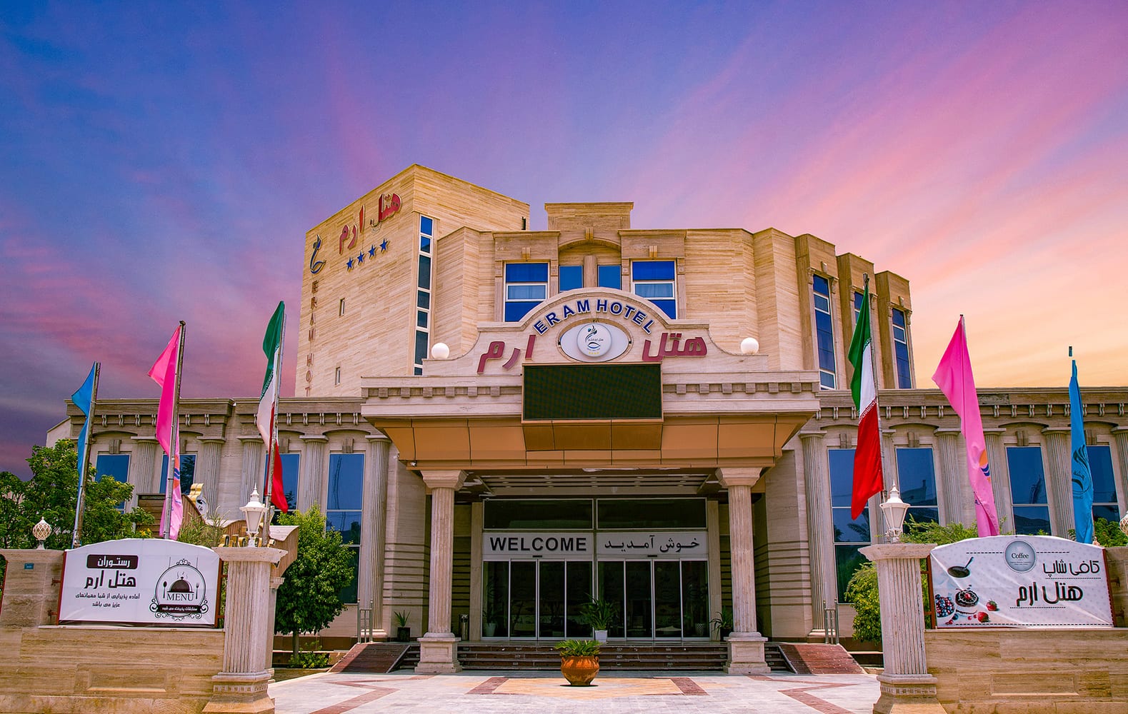 ورودی هتل ارم قشم با پرچم‌ها و تابلوی Eram Hotel