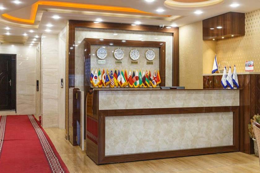 پذیرش و میز رسپشن هتل آپارتمان پرشیا قشم با ساعت‌های جهانی و پرچم‌ها