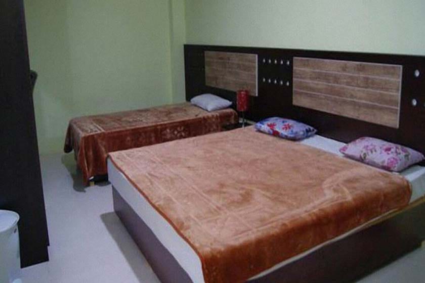 اتاق دوتختهٔ هتل پرشین گلف قشم با روتختی زرشکی