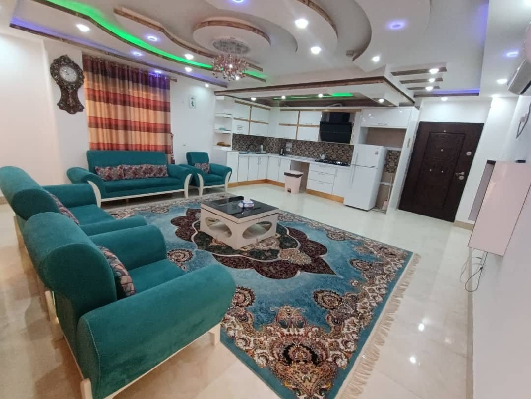 نشیمن مبله با مبل سبز و فرش در آپارتمان امپراطور قشم