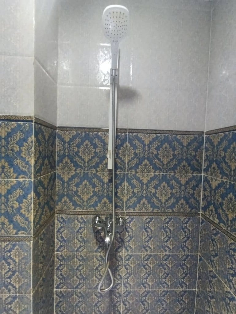 حمام با کاشی روشن و دوش در آپارتمان امپراطور قشم