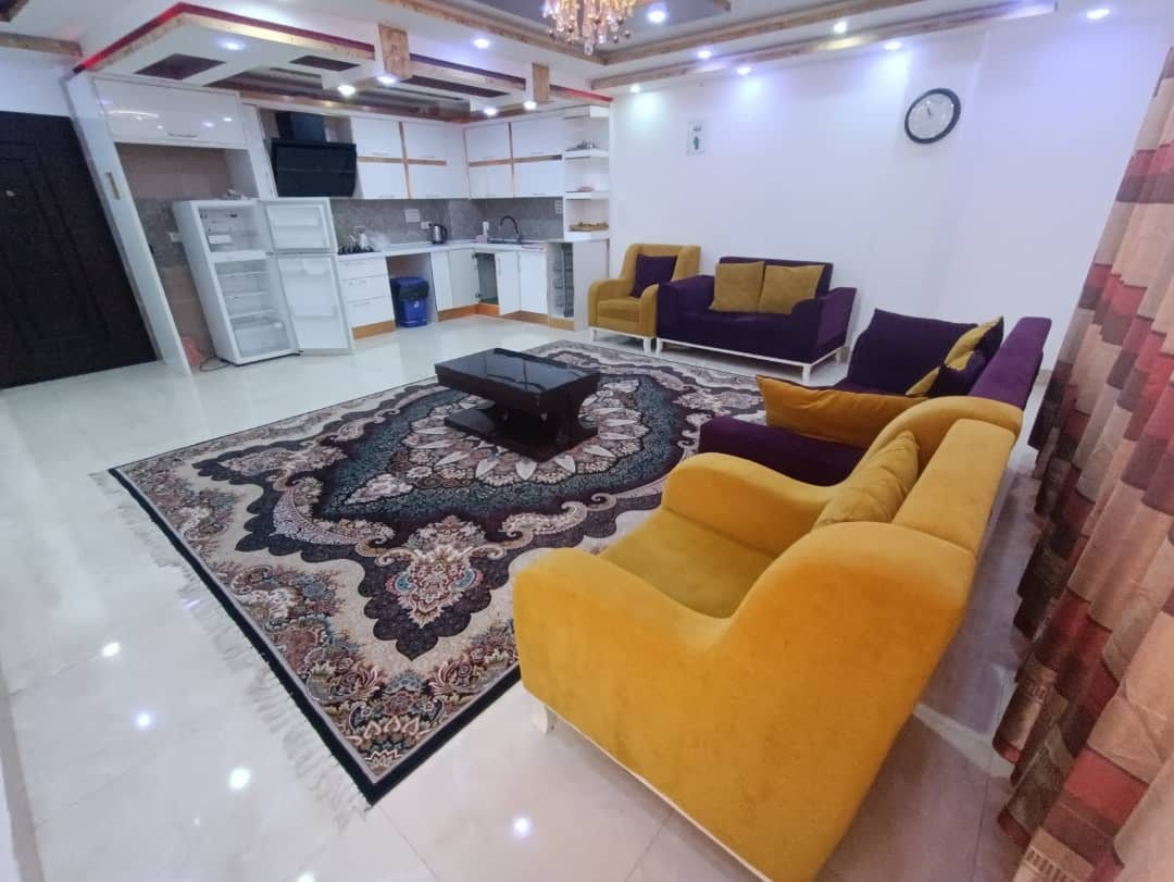 نشیمن با مبلمان زرد و فرش در آپارتمان امپراطور ۶ قشم