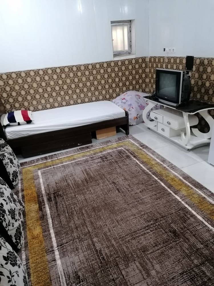 اتاق سوئیت توفان درگهان با تخت، تلویزیون روی میز و پنجرهٔ کوچک