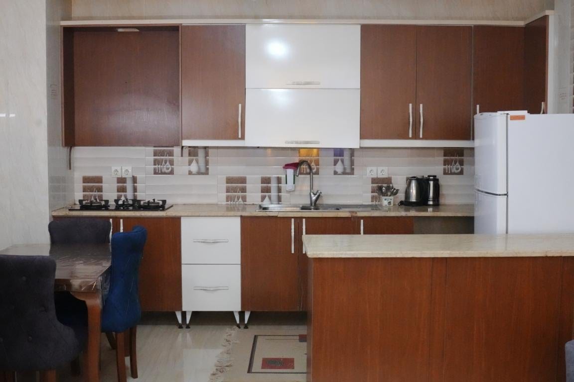 آشپزخانه با کابینت و یخچال در آپارتمان امید ممتاز واحد ۱۰۱ قشم