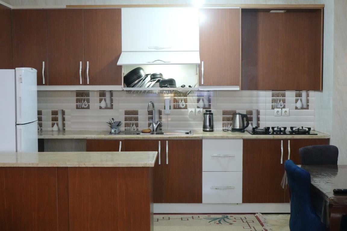 آشپزخانه با کابینت و یخچال در آپارتمان امید ممتاز واحد ۱۰۲ قشم
