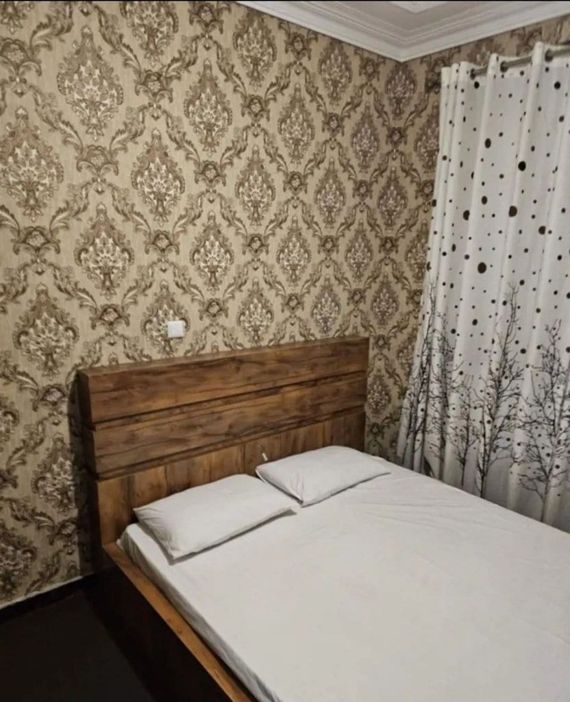 اتاق‌خواب با تخت دونفره و کاغذدیواری در آپارتمان دنیز قشم