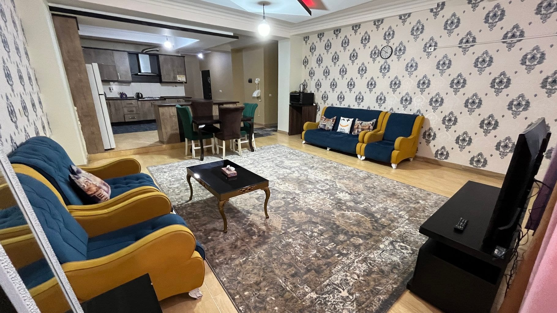آشپزخانه با کابینت چوبی و میز نهارخوری در آپارتمان ۱۲۰متری قشم