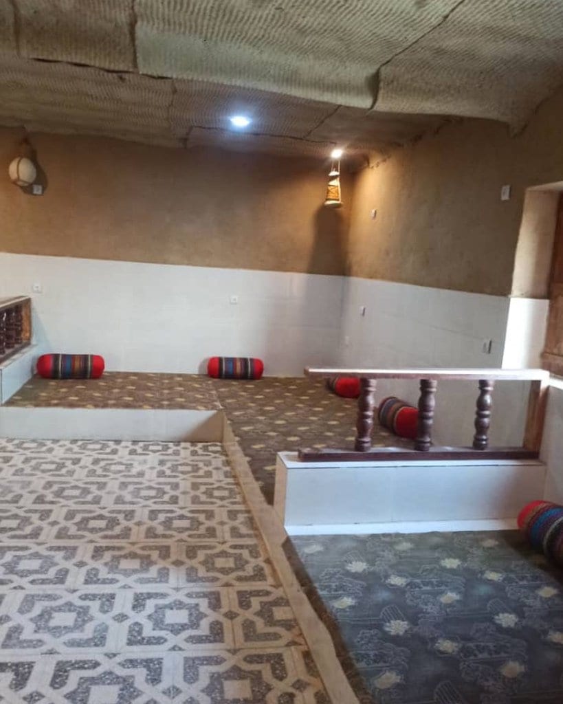 اتاق سنتی با نشیمن کف‌خواب و کفپوش طرح‌دار در بوم‌گردی چیرا واحد هنا قشم
