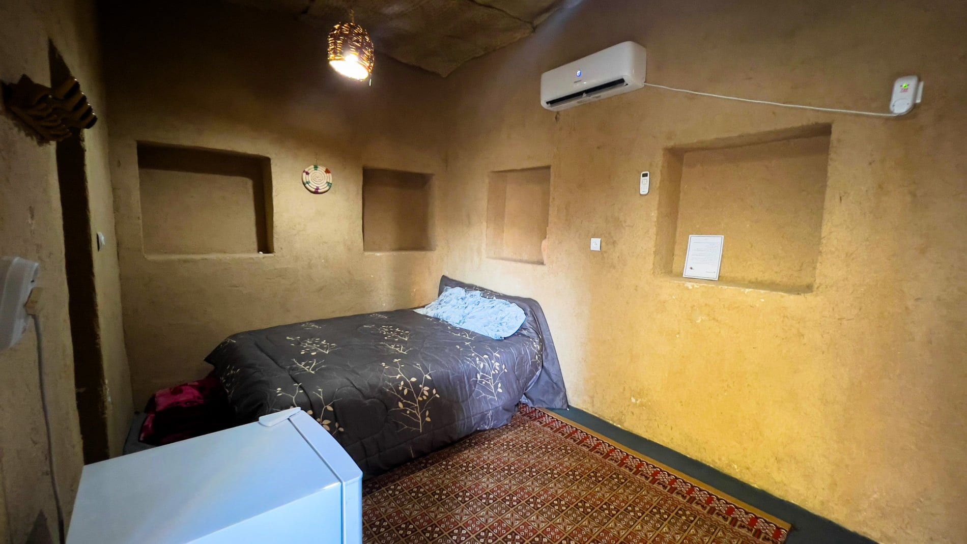 اتاق با تخت کف‌خواب و کولر دیواری در بوم‌گردی چیرا واحد سینگو قشم