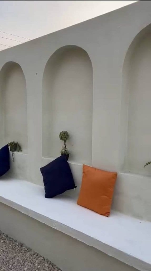 گوشهٔ نشیمن با کوسن‌های رنگی روی سکوی گچی در بوم‌گردی موم گپو قشم