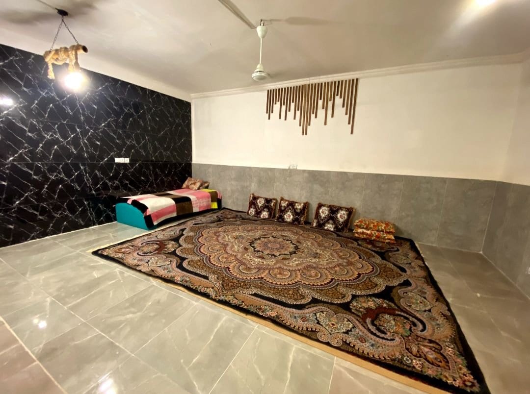 اتاق با فرش و رخت‌خواب سنتی روی کف در ویلا ساحلی حسین هرمز