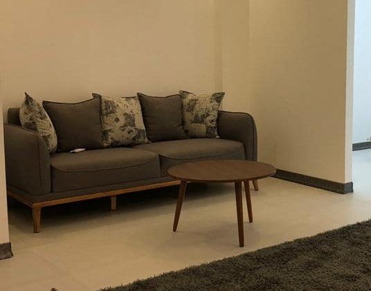 مبل پارچه‌ای طوسی با کوسن در نشیمن آپارتمان شمسی‌پور قشم