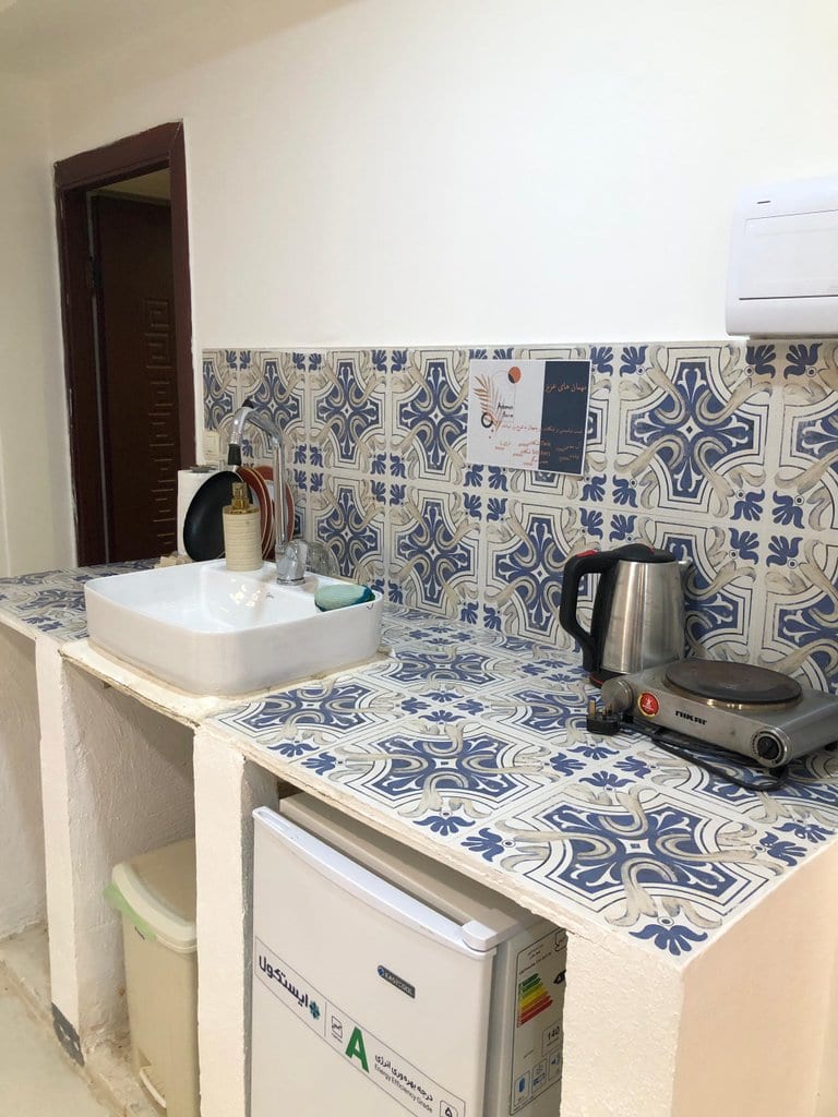 کابینت آشپزخانه با بک‌اسپلش کاشی آبی طرح‌دار در سوئیت قشم