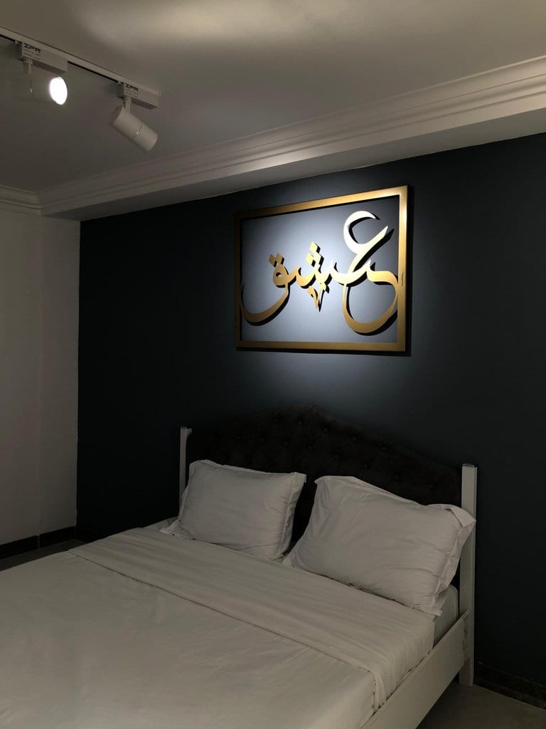 تخت دونفره سوئیت قشم با تابلوی نورپردازی‌شدهٔ دیواری