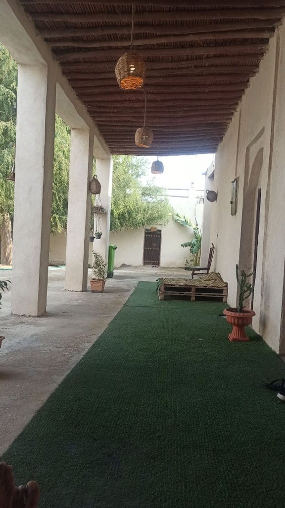 ایوان بیرونی با چمن مصنوعی و ستون‌ها در بوم‌گردی چیرا قشم