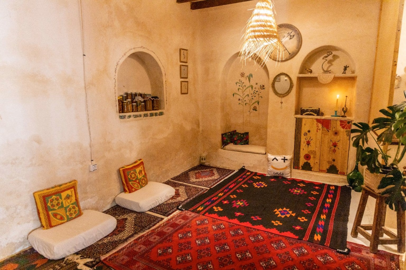 اتاق سنتی با سقف گنبدی سفید، گلیم و طاقچه‌های قوسی در بوم‌گردی ماتوسکا هرمز