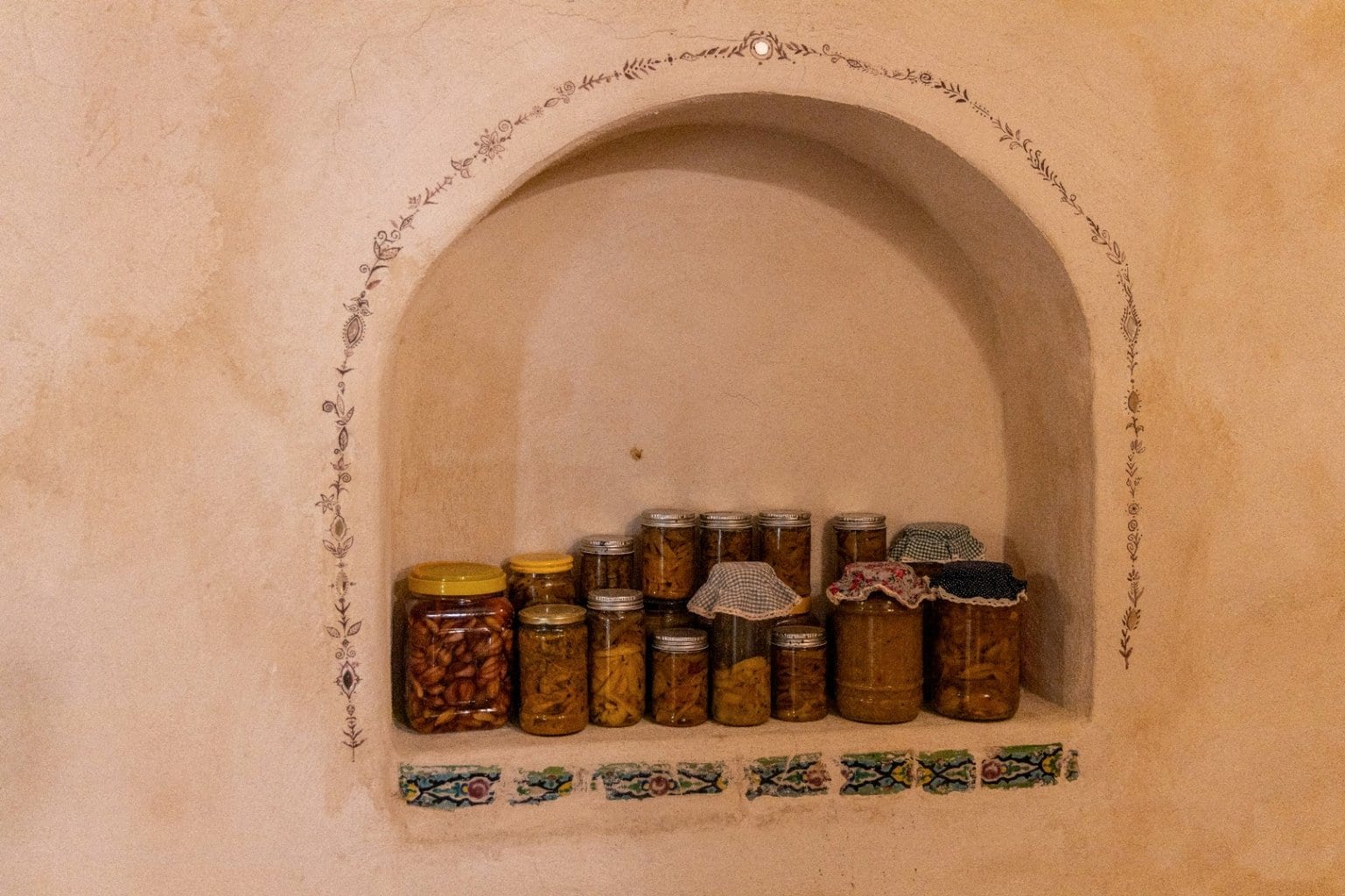 طاقچهٔ قوسی با ردیف ظروف سفالی نگهداری در بوم‌گردی ماتوسکا هرمز