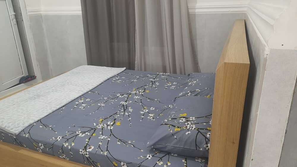 تخت‌خواب با روتختی طوسی در ویلای کلودنگ هرمز