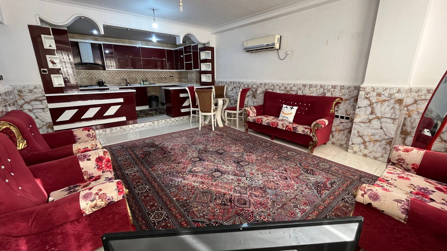 اتاق‌خواب با فرش قرمز و دیوارپوش سنگی در آپارتمان قشم