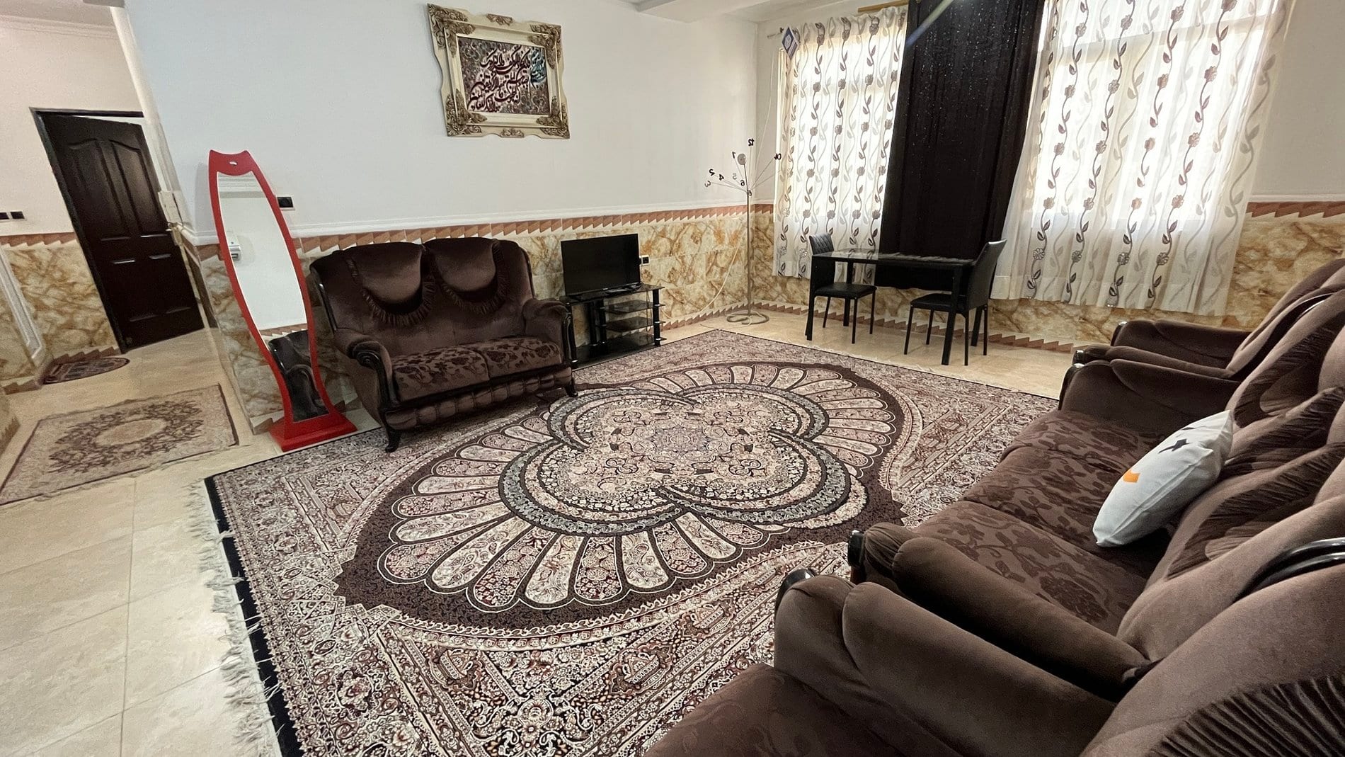 پذیرایی با مبلمان و فرش گرد در آپارتمان ۱۱۰متری مرکز شهر قشم