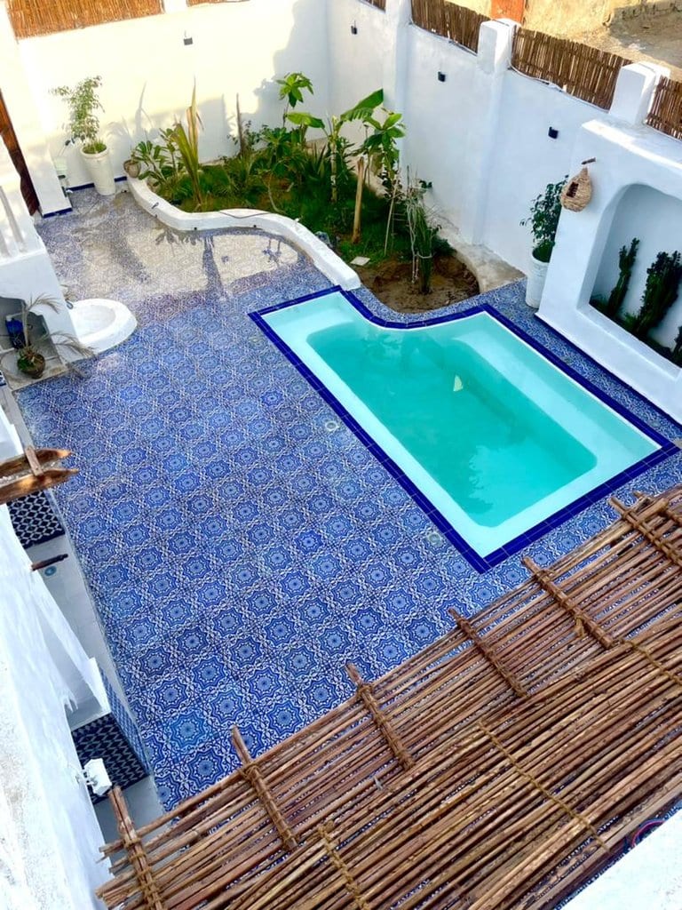 استخر فیروزه‌ای با کف‌پوش چوبی در اقامتگاه بوم‌گردی خانه ماهی قشم