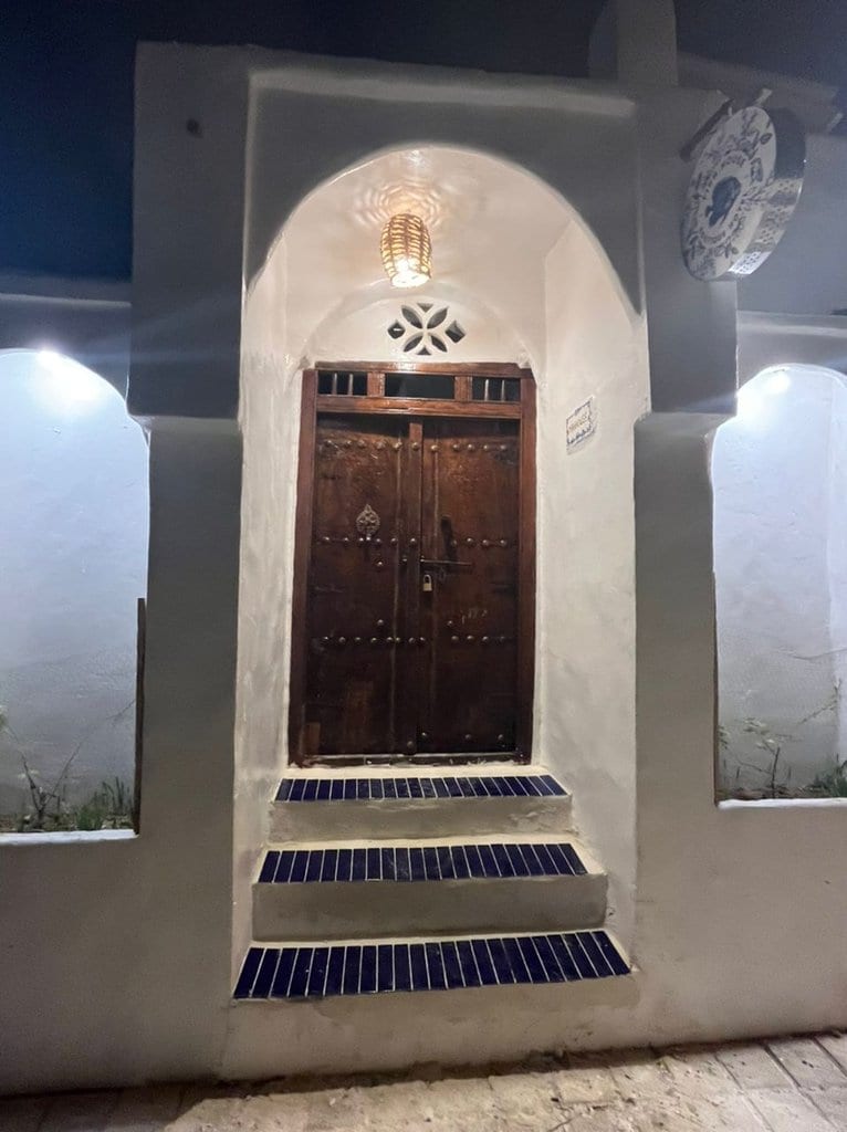 درِ چوبیِ سنتیِ تزیین‌شده در اقامتگاه بوم‌گردی خانه ماهی قشم