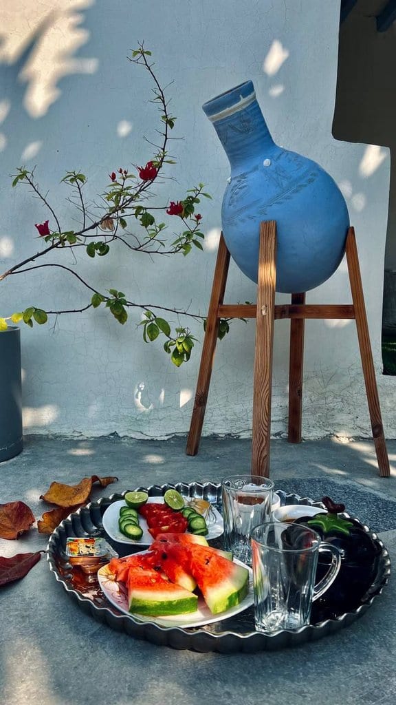 پذیرایی سنتی با سینی میوه و سبوی آبی در بوم‌گردی گل ابریشم قشم