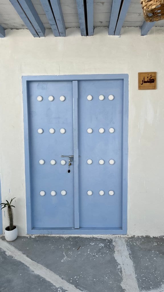 درِ دولنگهٔ چوبیِ آبی، ورودی واحد در بوم‌گردی گل ابریشم قشم