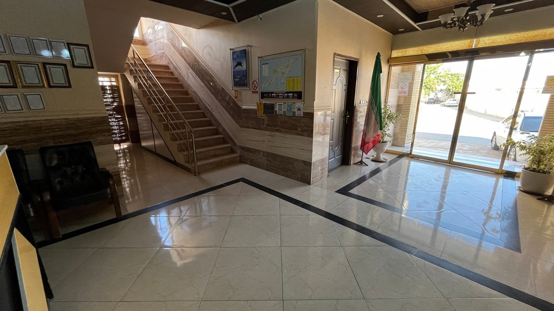 لابی مجتمع اقامتگاهی پونه قشم با راه‌پله، کف سنگ و ورودی شیشه‌ای