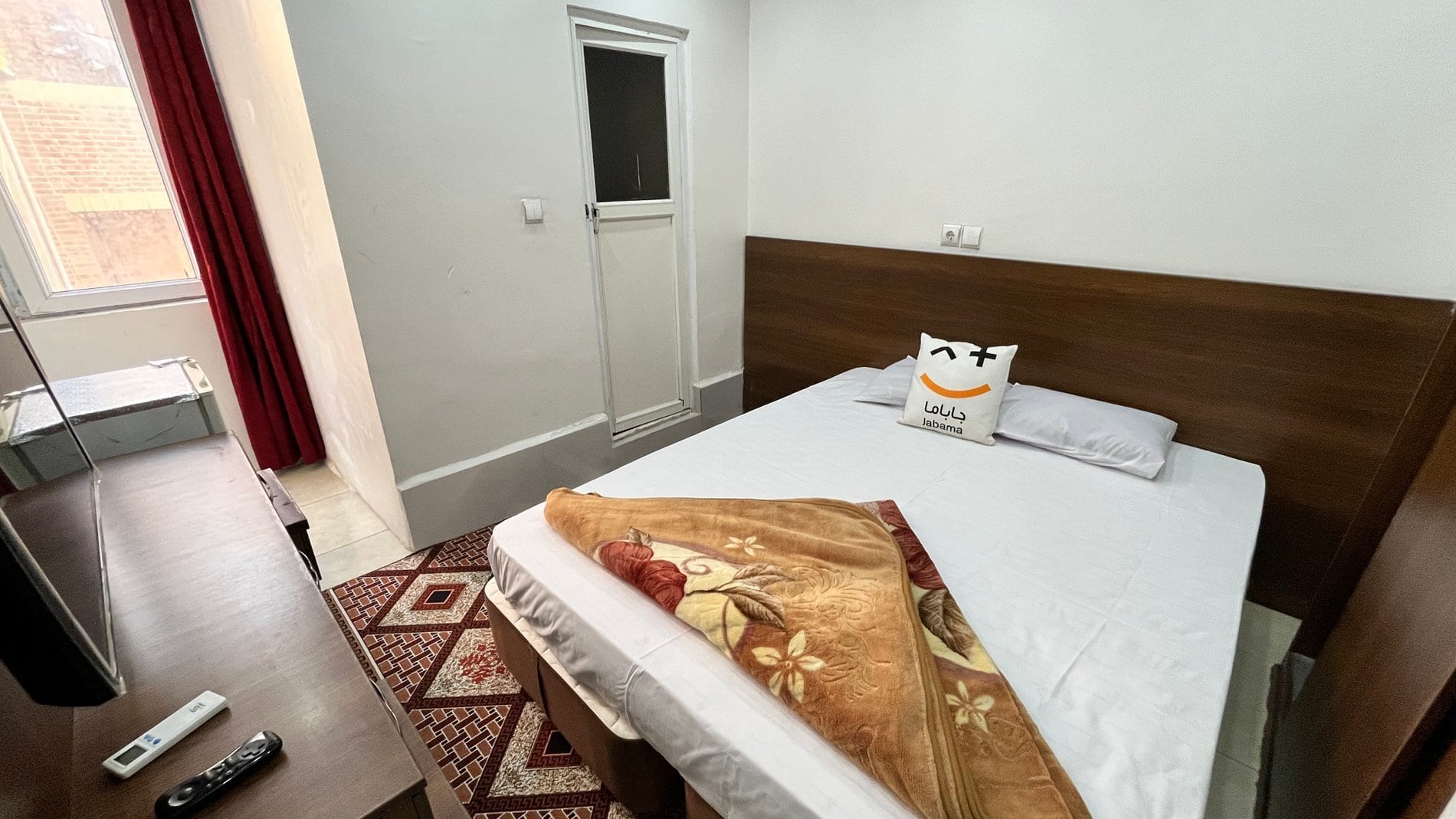اتاق با تخت دونفره و دیوار روشن در مسافرخانهٔ دونفره قشم