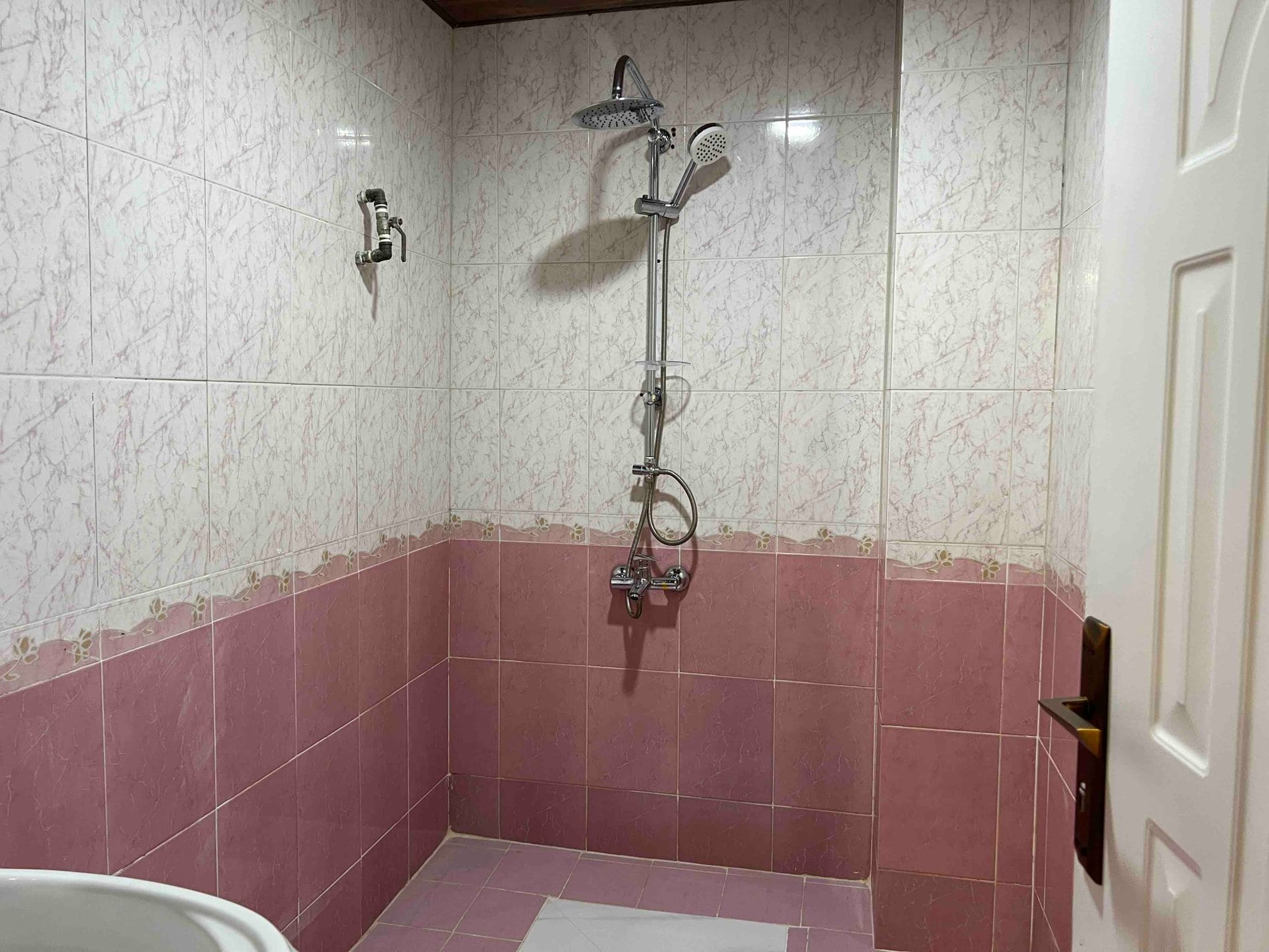 حمام با دوش و کاشی‌کاری صورتی در آپارتمان آسا هوم قشم