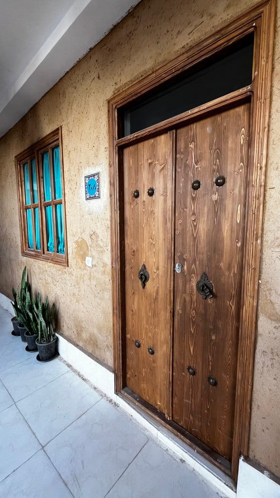 درِ چوبیِ سنتیِ ورودی در مجتمع اقامتگاهی دال قشم