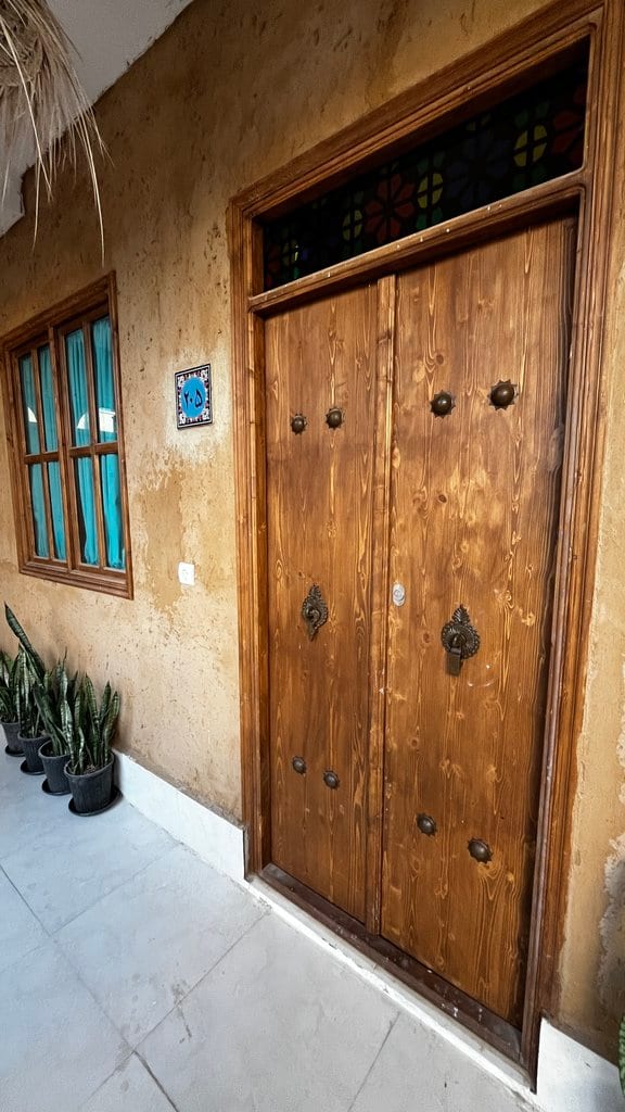 درِ چوبیِ بزرگ و سنتیِ منبت‌کاری‌شده در مجتمع اقامتگاهی دال قشم