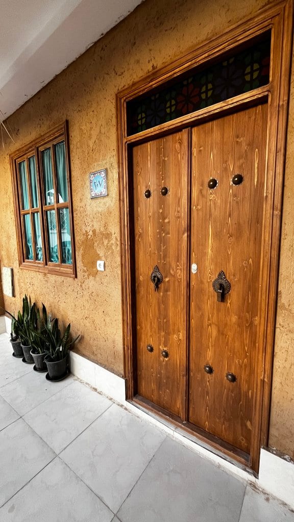 درِ چوبیِ دولنگهٔ سنتیِ ورودی واحد در مجتمع دال قشم