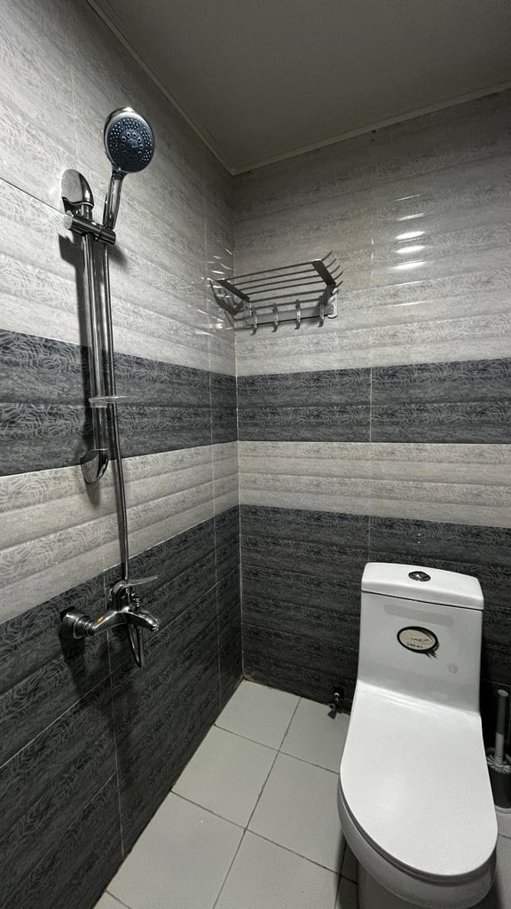 حمام و دوش با کاشی‌کاریِ خاکستری در واحد مجتمع دال قشم