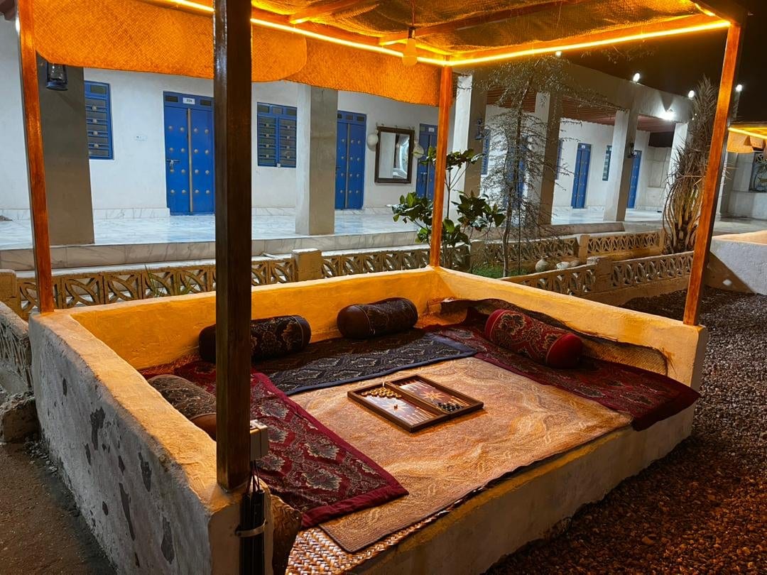 اتاق سنتی با نور گرم و رخت‌خواب روی فرش در بوم‌گردی لاور قشم