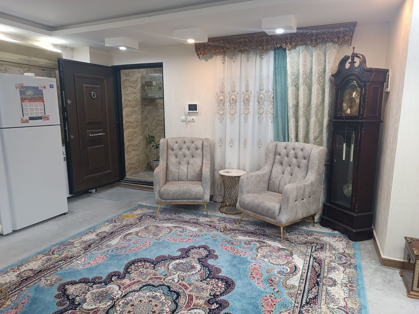 نشیمن با تلویزیون و مبلمان فیروزه‌ای در آپارتمان فیروزه‌ای قشم