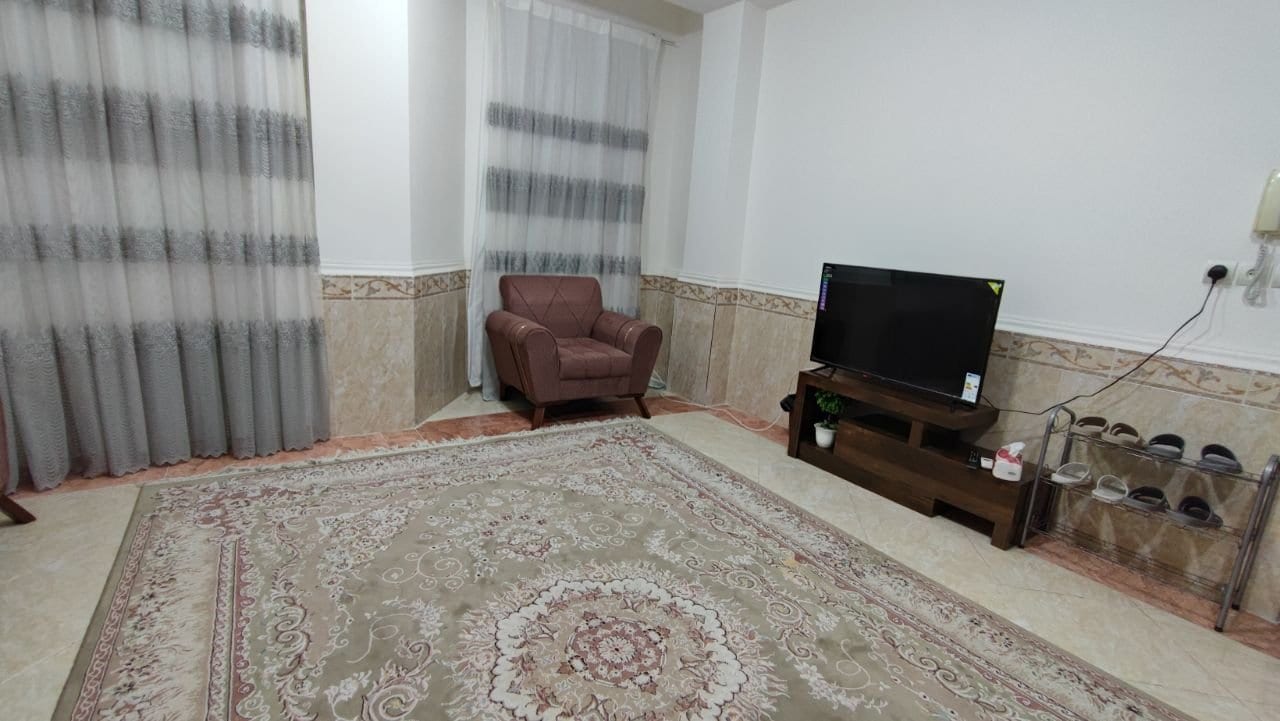 نشیمن با مبل و تلویزیون در آپارتمان دوخوابه دانشمند ۳ شهرک نریمان قشم