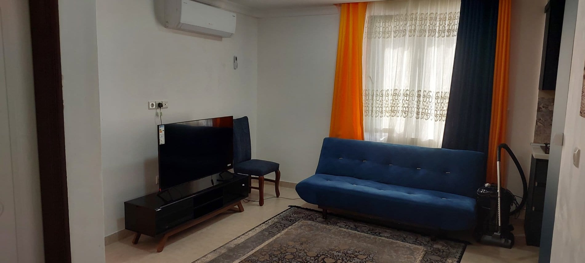 نشیمن با مبل تیره و میز تلویزیون در آپارتمان امید ممتاز واحد ۲ قشم