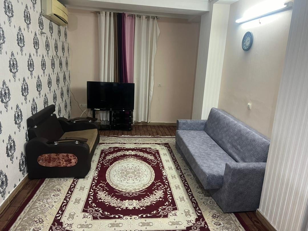 نشیمن با مبلمان راحتی، فرش دستباف و پرده در آپارتمان ۶۰متری اقتصادی قشم