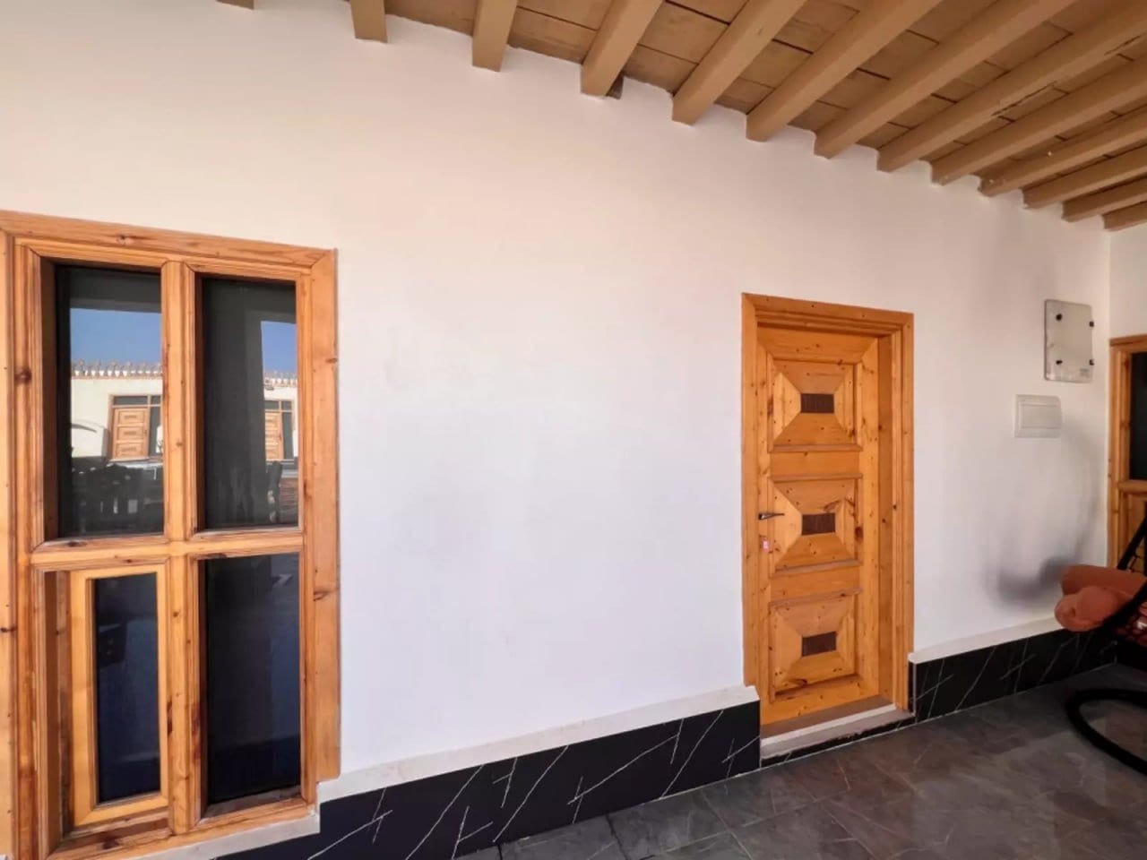 پنجرهٔ گچ‌بری‌شدهٔ سنتی روی دیوار کاهگلی در بوم‌گردی خماسی هنگام