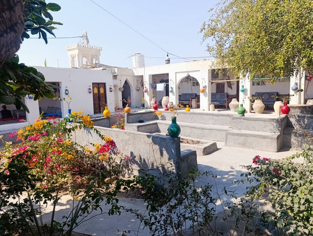 تخت دونفره با رخت‌خواب سنتیِ رنگی در واحد گل نرگس بوم‌گردی ناخدا علی قشم