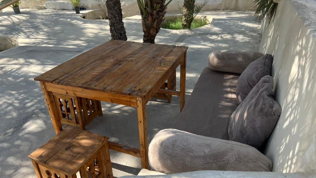 میز و صندلی چوبی فضای باز روی تراس بوم‌گردی چهارخوابه قشم