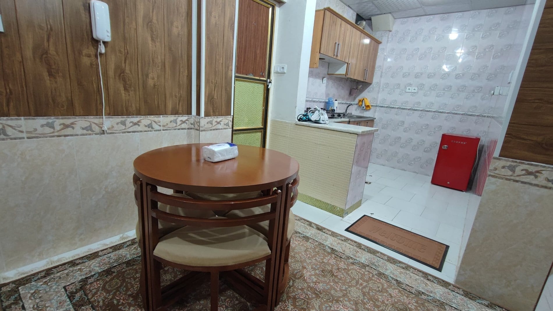 میز نهارخوری چوبی کنار آشپزخانه در آپارتمان یک‌خوابه دانشمند ۳ قشم