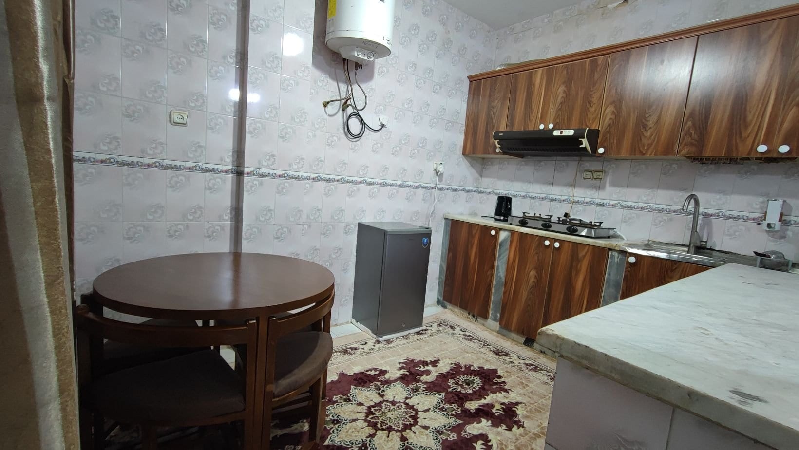 آشپزخانه با کابینت و میز نهارخوری در سوییت دانشمند ۱ قشم