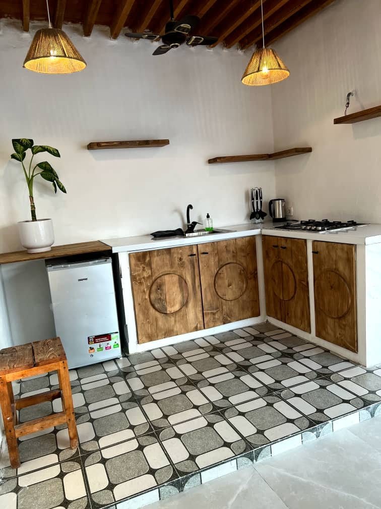 آشپزخانهٔ باز با کابینت و کف‌پوش سنتی در بوم‌گردی لومبور قشم