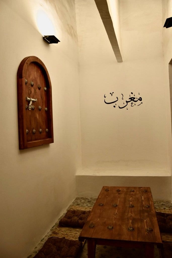 درگاه قوسی و دیوار گچ‌بری‌شده با خط «مغرب زمین» در بوم‌گردی مغرب قشم