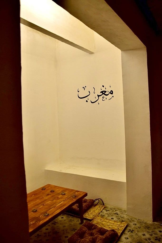 دیوار گچ‌بری‌شده با خوش‌نویسی «مغرب زمین» در بوم‌گردی مغرب قشم