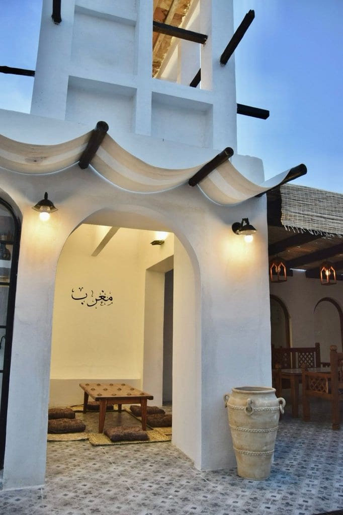 ورودی قوسی با تزیینات گچی و چراغ دیواری در بوم‌گردی مغرب قشم